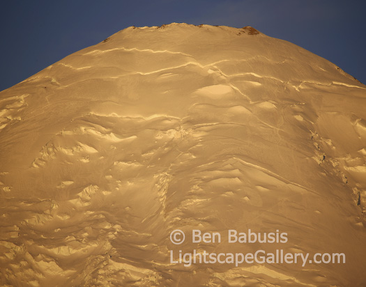 Rainier Dawn. Mt. Rainier, Washington. 
The yellow glow of predawn light hit Mt. Rainier (14,410 ft). The Emmons glacier climbing route can be seen winding up the peak.  Ben Babusis, Lightscape Gallery.