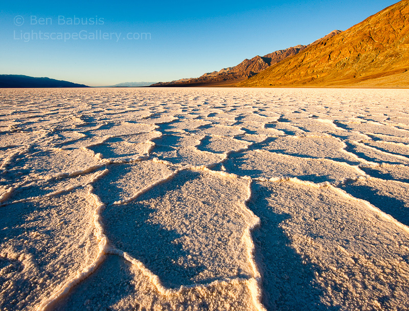 Salty Sunrise. Badwater Basin, Death Valley. Winter sunrise on Badwater Basin in Death Valley National Park (282 feet below sea level). Early morning light enhances the geometric shapes formed by water pooling on the salt formation.  Ben Babusis, Lightscape Gallery.