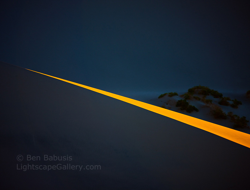 Lightspear. Death Valley, CA. A sharp spear of light pierces the morning darkness on the Stovepipe Wells Dunes in Death Valley.  Ben Babusis, Lightscape Gallery.