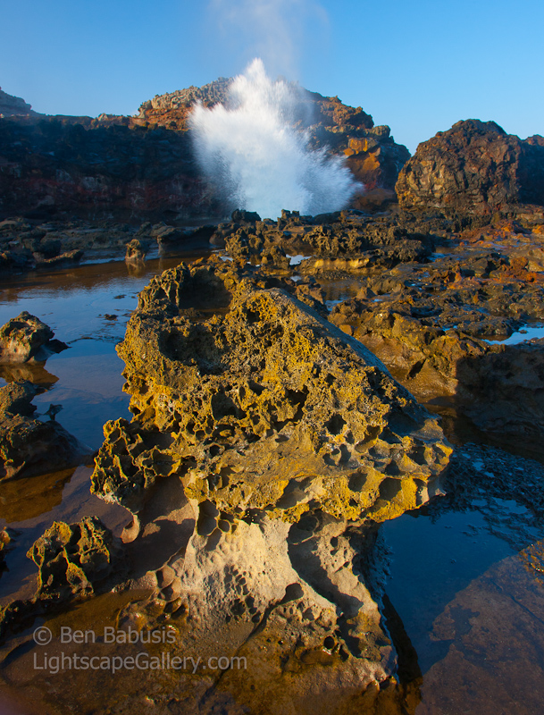 Lavarock Eruption. West Maui, Hawaii. Lava rock detail at sunset with the Nakalele Blowhole erupting in background.  Ben Babusis, Lightscape Gallery.