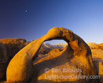 Mobius Arch and Moon. Alabama Hills, California. A rock arch in the Alabama Hills catches the first rays of sun as the moon hovers overhead. The arch frames Mt. Whitney, the highest peak in the continguous 48 states at 14,495 feet.  Ben Babusis, Lightscape Gallery.