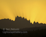 Minarette Silhouette. Mammoth Lakes, California. The setting sun silhouettes the razor sharp profile of the Minarettes near Mammoth Lakes. The rays extending from the peaks are a consequence of smoke in the air from recent forest fires.  Ben Babusis, Lightscape Gallery.