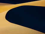 Dark Side of the Dune. Death Valley, CA. Sun bathed sand crisply outlines the utter blackness of the northern slope of this sand dune in Stovepipe Wells.  Ben Babusis, Lightscape Gallery.